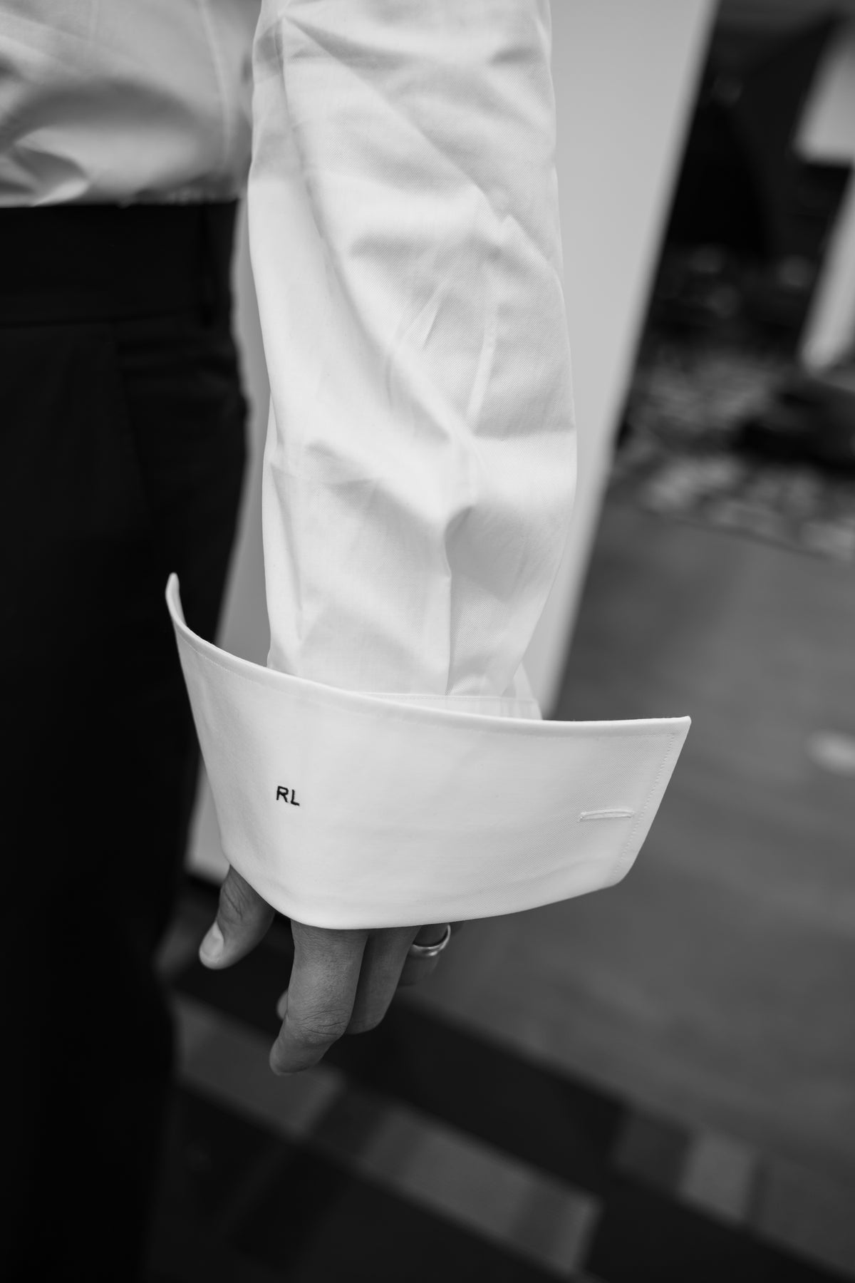 Un poignet de chemise blanche monogrammé.