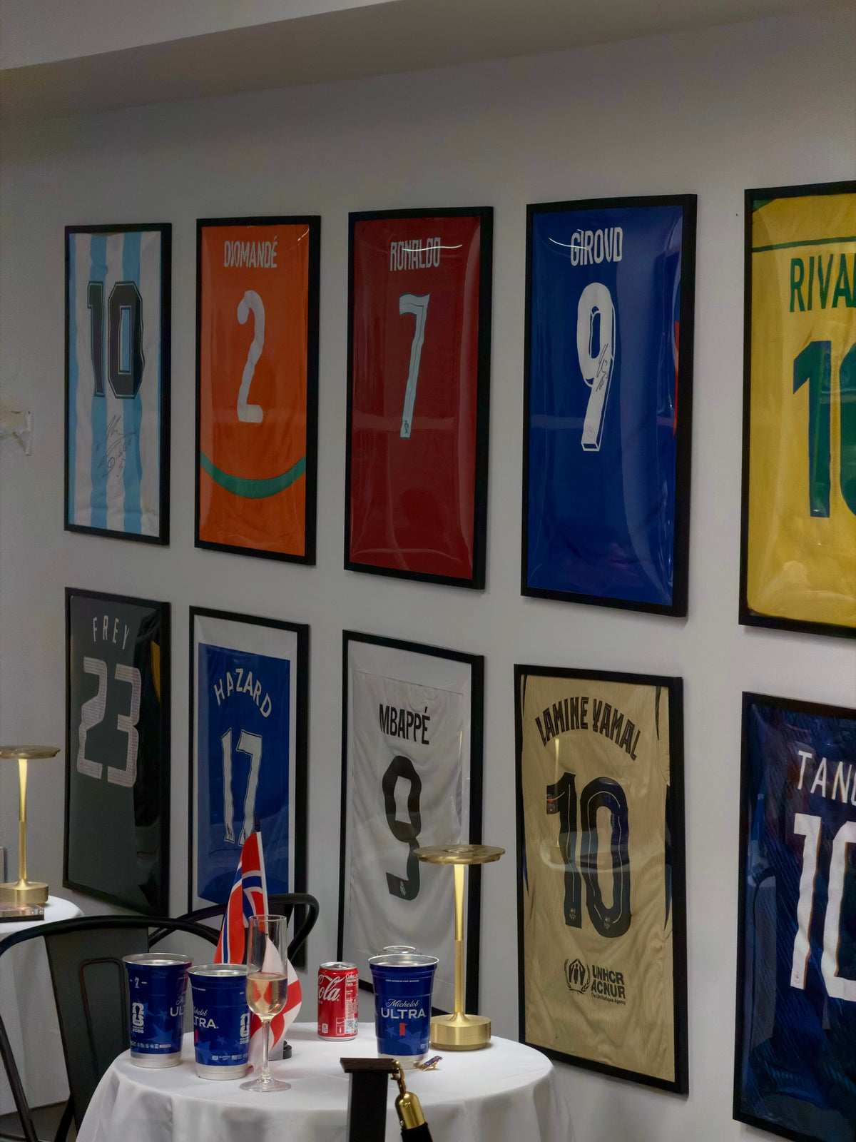Framed football shirts arranged as a gallery inside The Proper Stadium