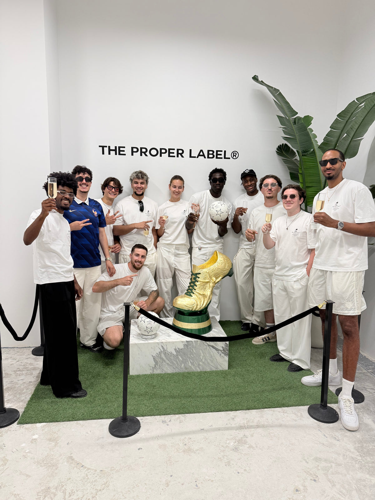 A gathering around the gold football boot sculpture inside The Proper Stadium