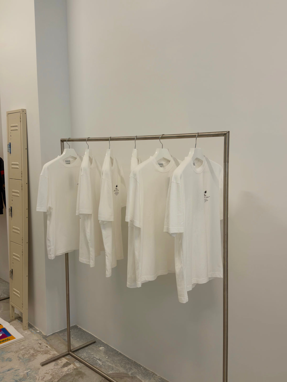 White Proper Label T-shirts from the main line displayed on a rail inside The Proper Stadium