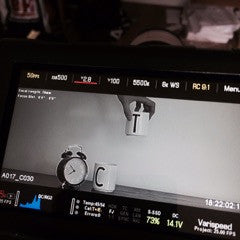 Un moniteur de tournage montre un réveil, une tasse portant la lettre C et une main tenant une tasse portant la lettre T.