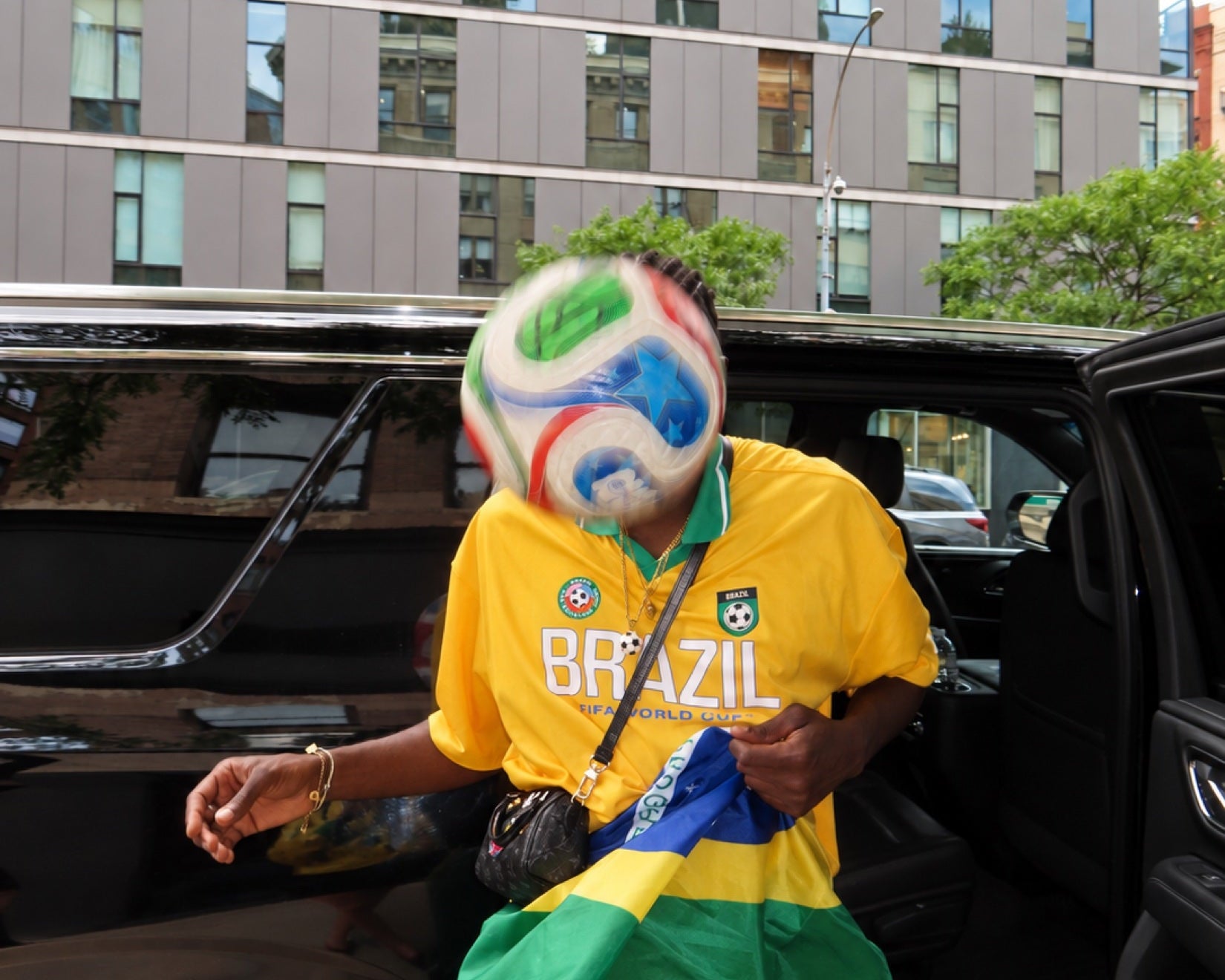 A moving ball interrupts an ordinary street photograph.