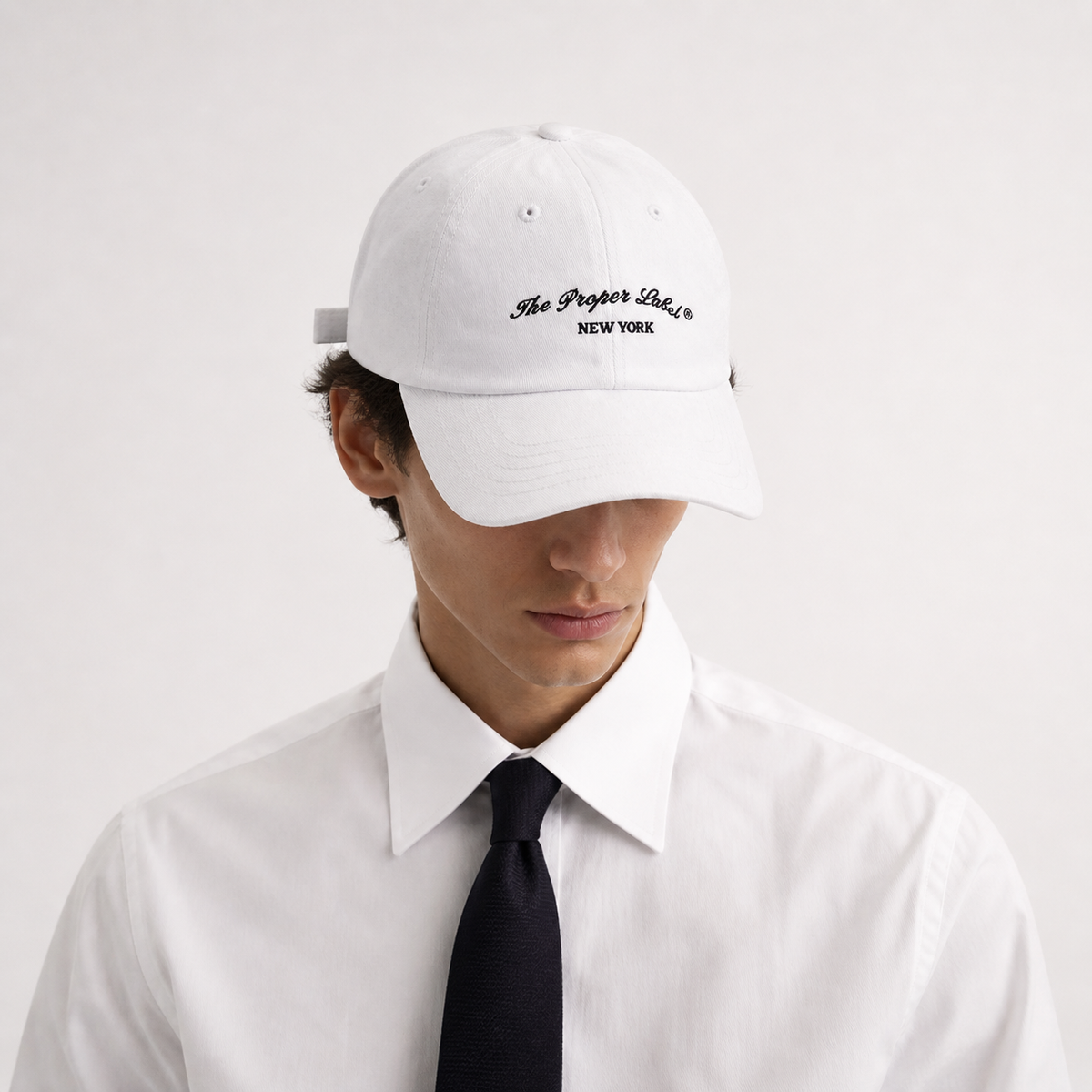 Signature Proper Cap — Blanc — worn with white shirt and black tie