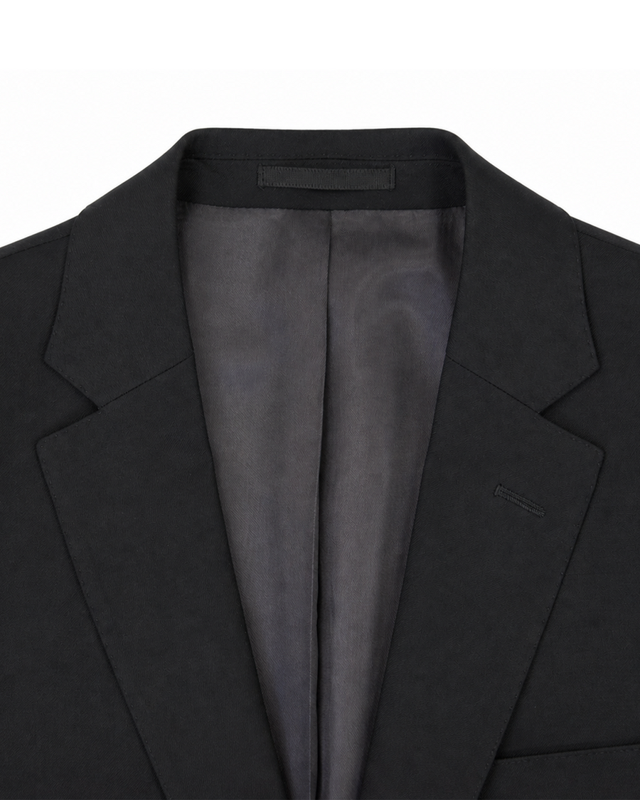 Étude des revers et de la doublure d’un blazer noir, expression du langage tailoring de la Maison