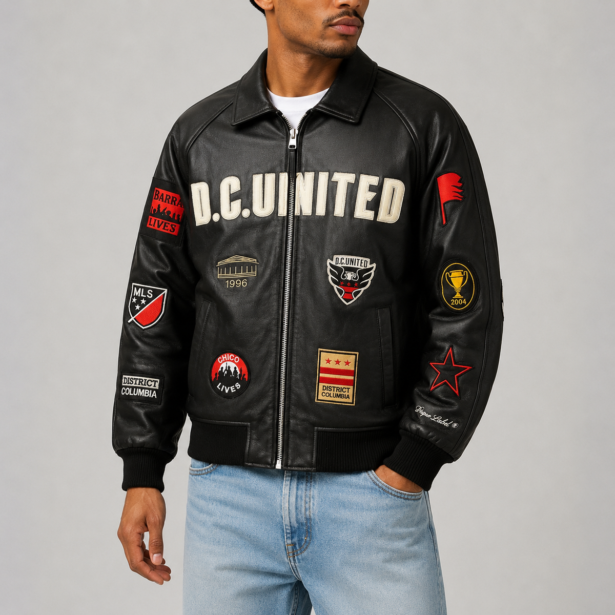 D.C. United District Legacy leather jacket worn with a white T-shirt and blue denim, showing the original club patches and embroidery.