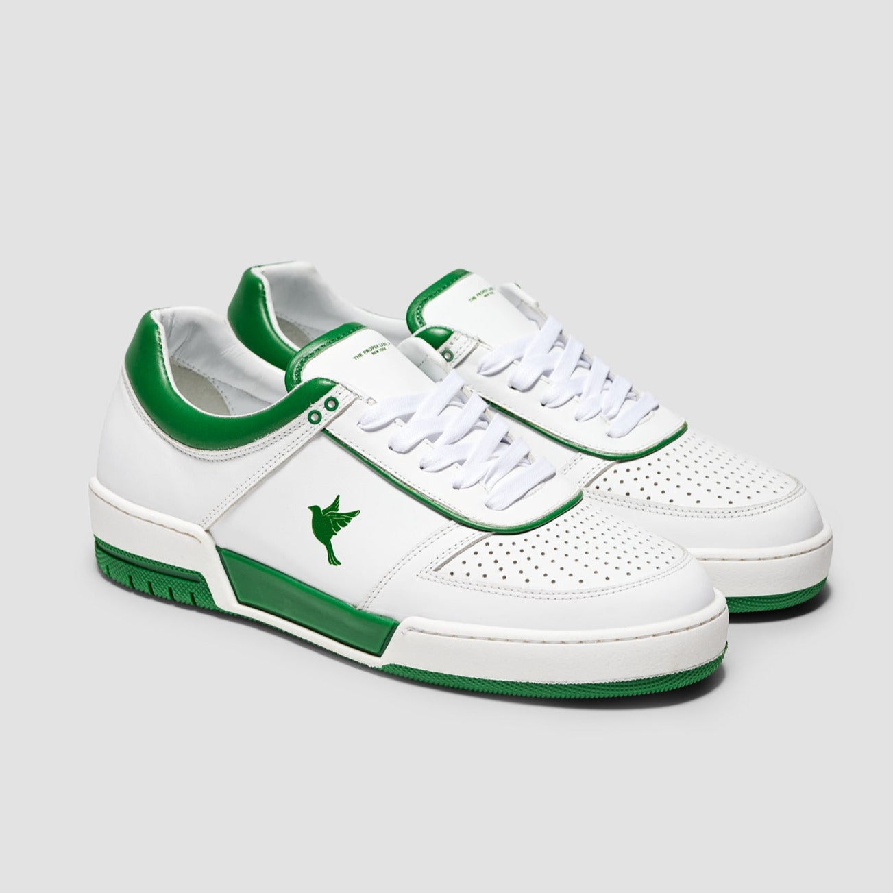 White sustainable sneakers with Renaissance Green accents, showcasing a 3D-printed dove emblem on the side.