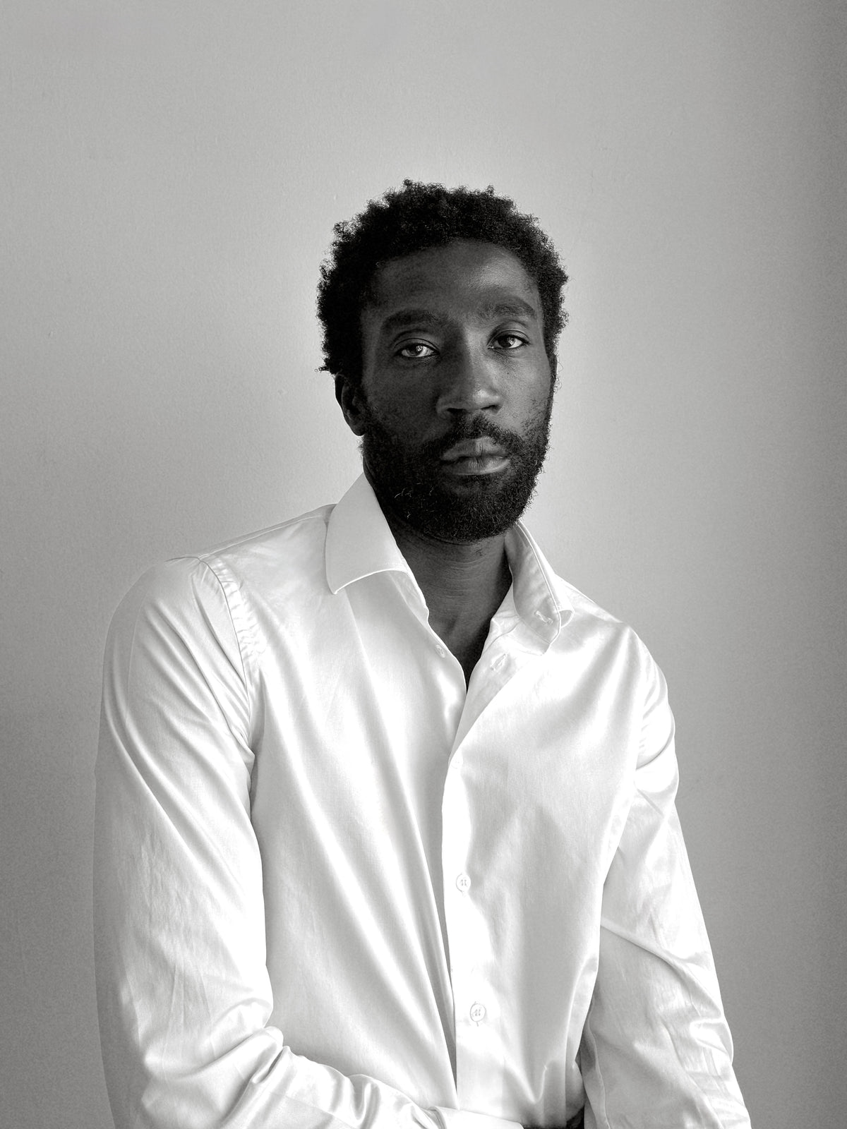 Black-and-white portrait of Camille Tanoh, founder and creative director of The Proper Label, wearing a white shirt.