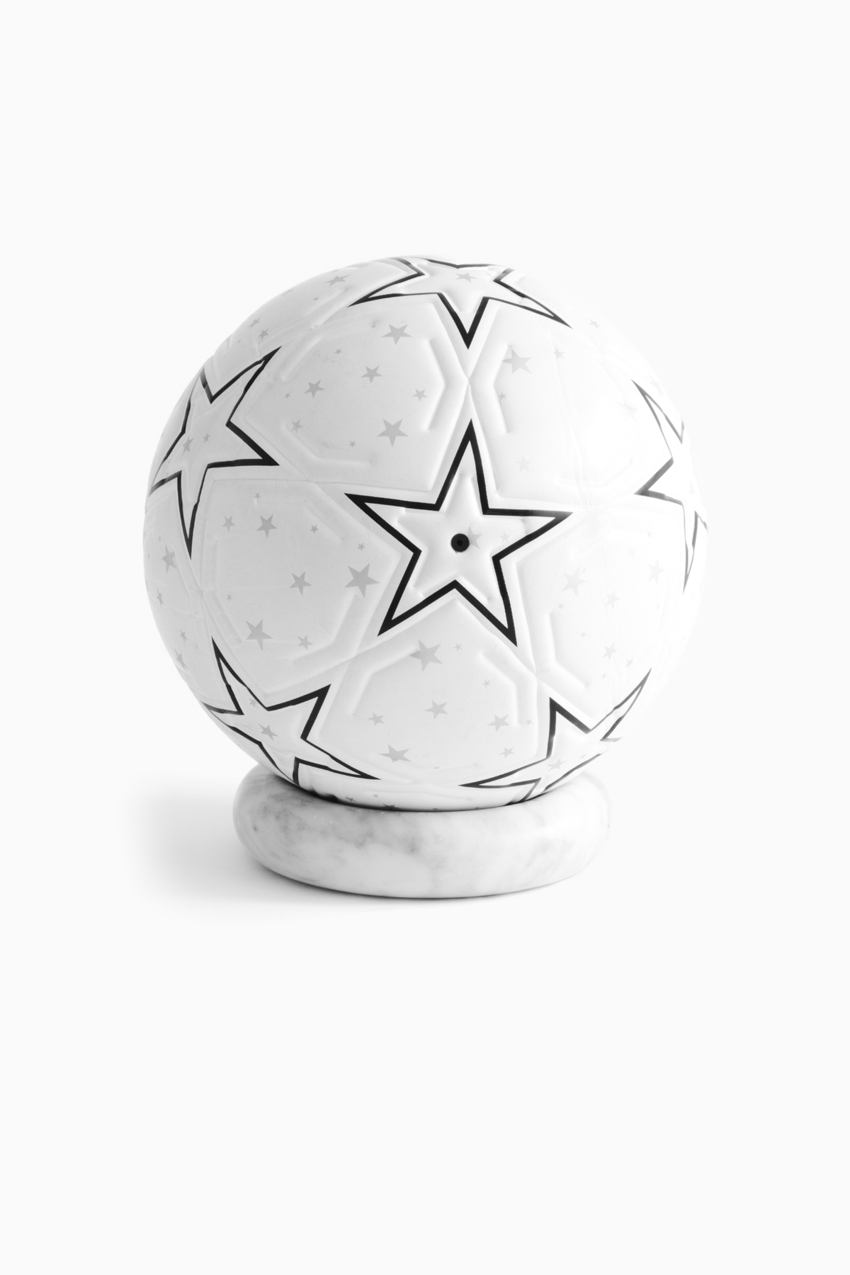The Proper Starball — valve-side studio view on a marble stand.