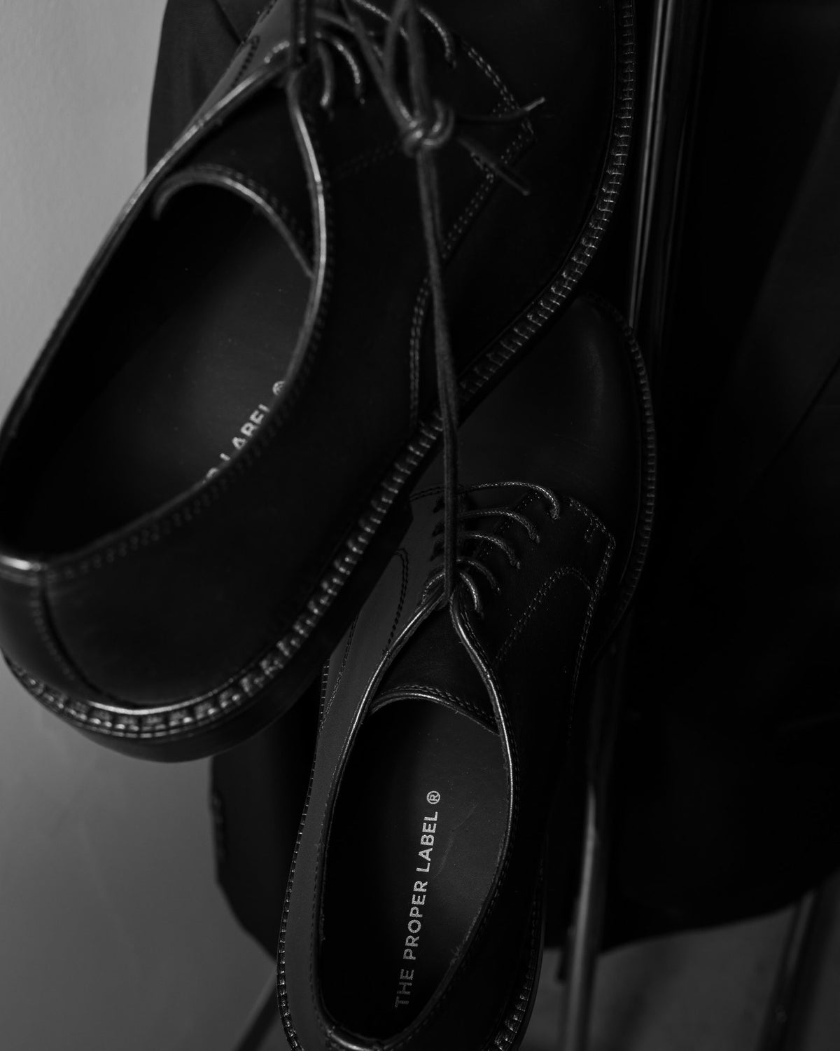 Close view of historical black lace-up shoes and their original insole branding. Maison de Sport — Collection 005. Photography: Malike Sidibé, New York.