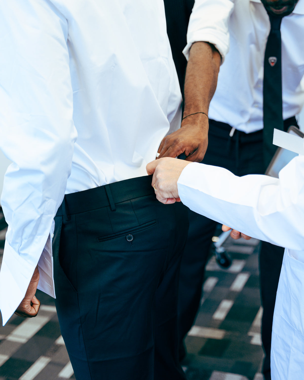 Ajustement à la main de la ceinture d’un pantalon.