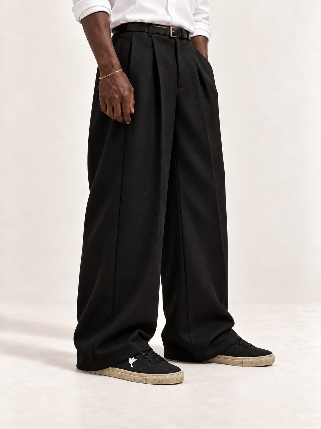 HEMPTON black sneakers with wide double-pleat black trousers and a white shirt.