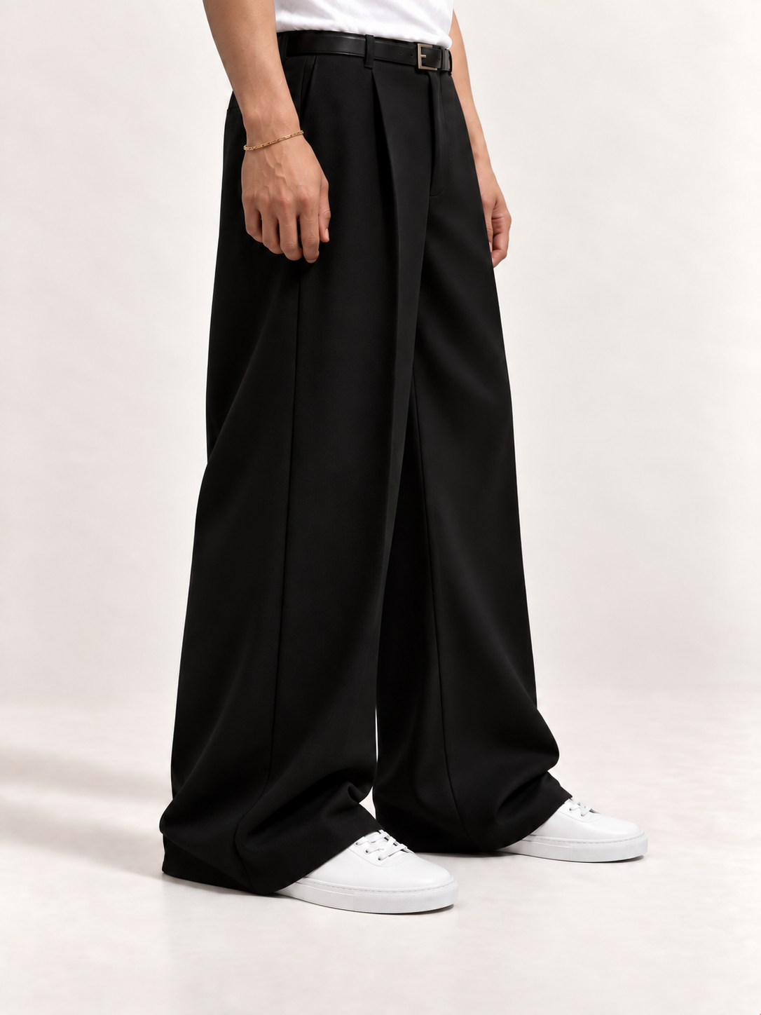 Proper Sneaker in white with fluid black trousers and a white T-shirt.