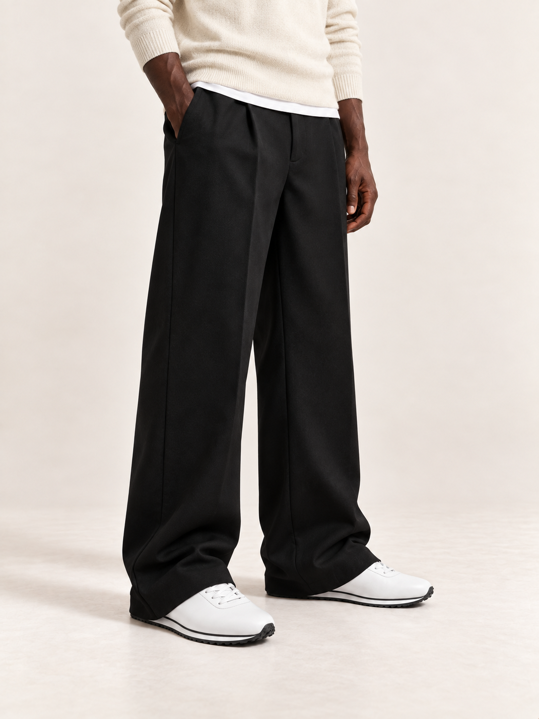 Proper Runner in white with soft black trousers and cream knitwear.