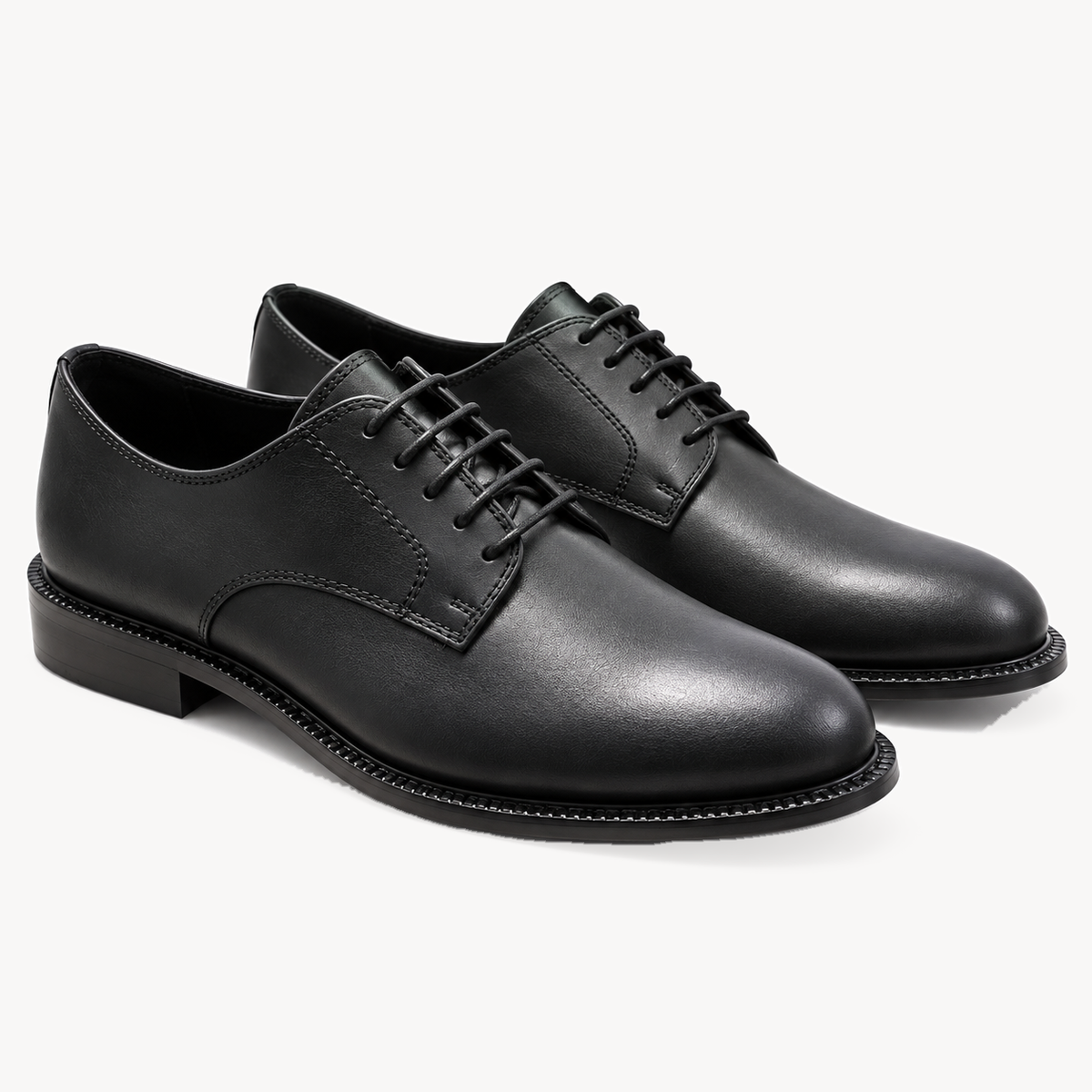 The Legacy Derby — black leather pair, three-quarter view.