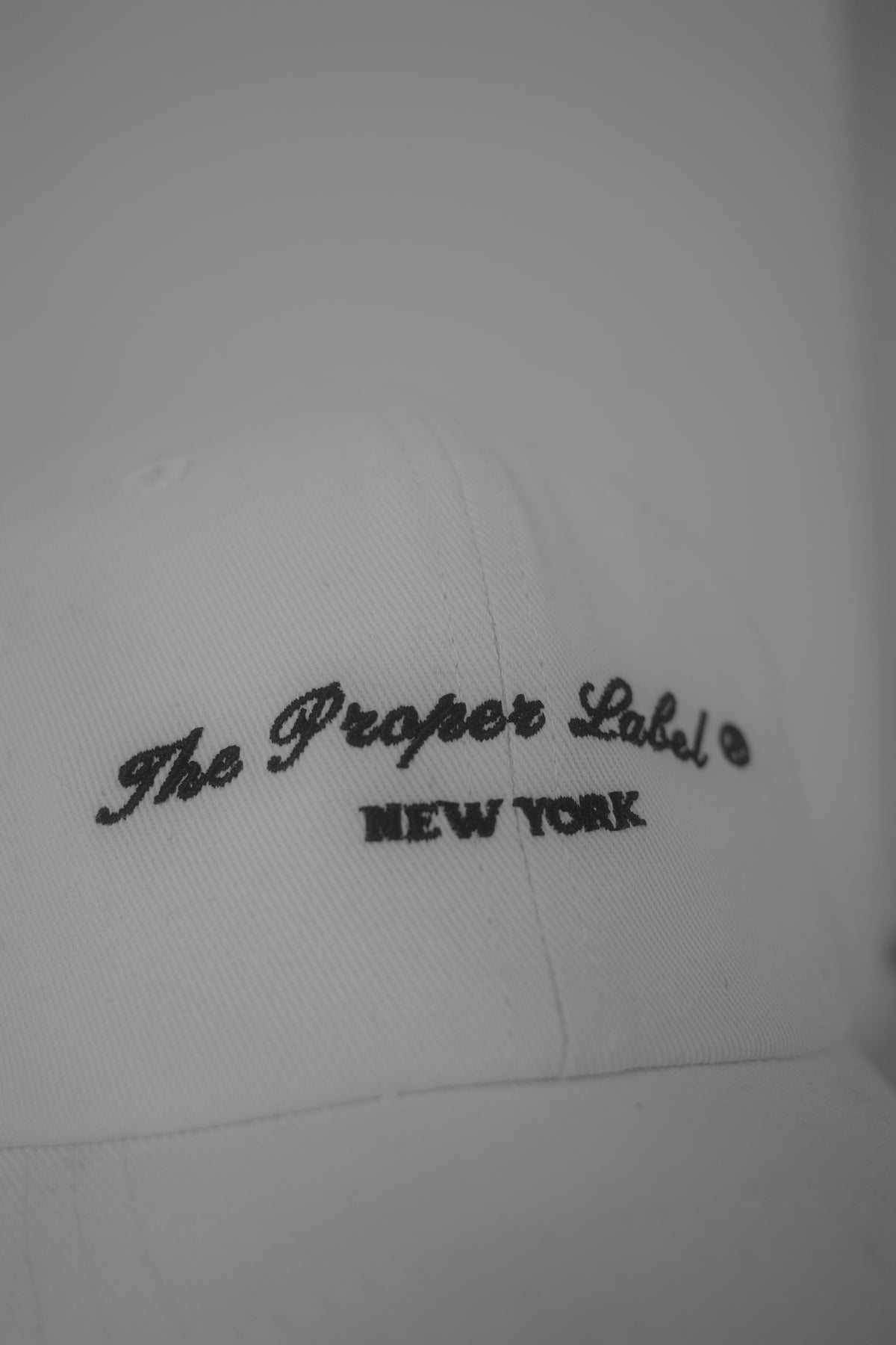 The Proper Label New York embroidered on a white cap.