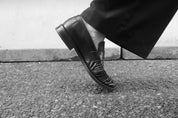 A close study of Julia's black leather loafer and tailored trouser hem.