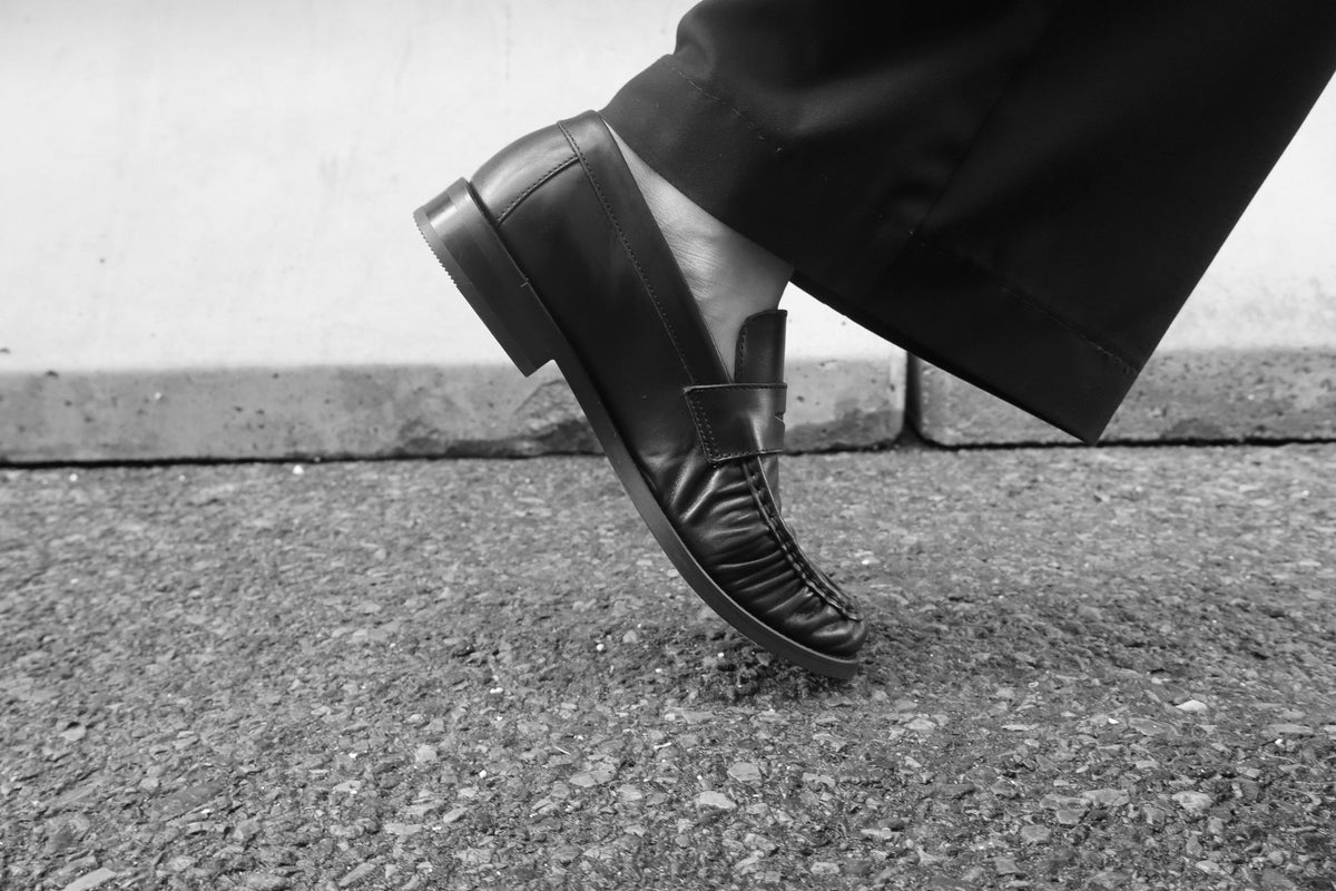 A close study of Julia's black leather loafer and tailored trouser hem.