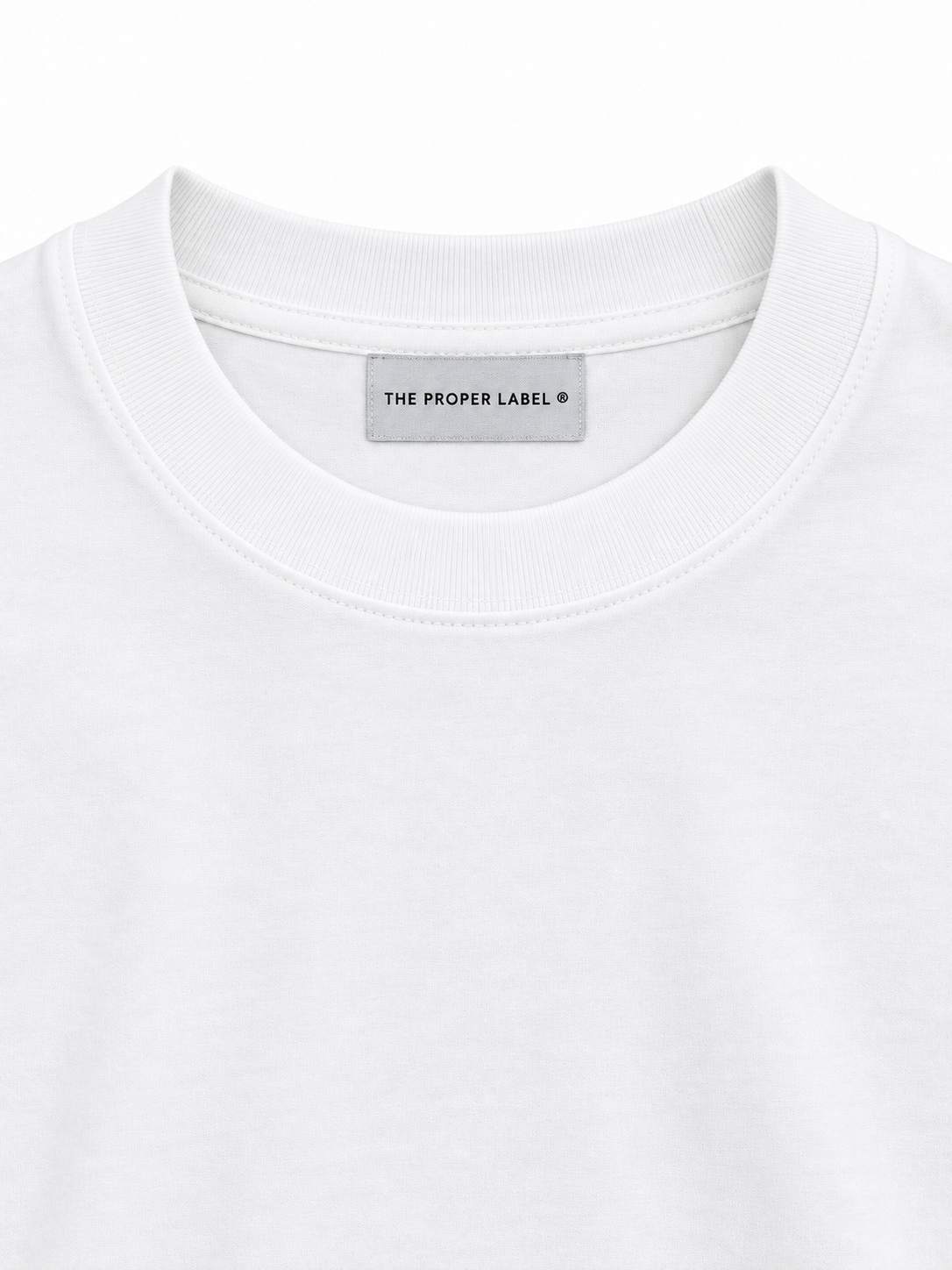 Studio close-up of the white ribbed crew neck, cotton and single The Proper Label woven label.