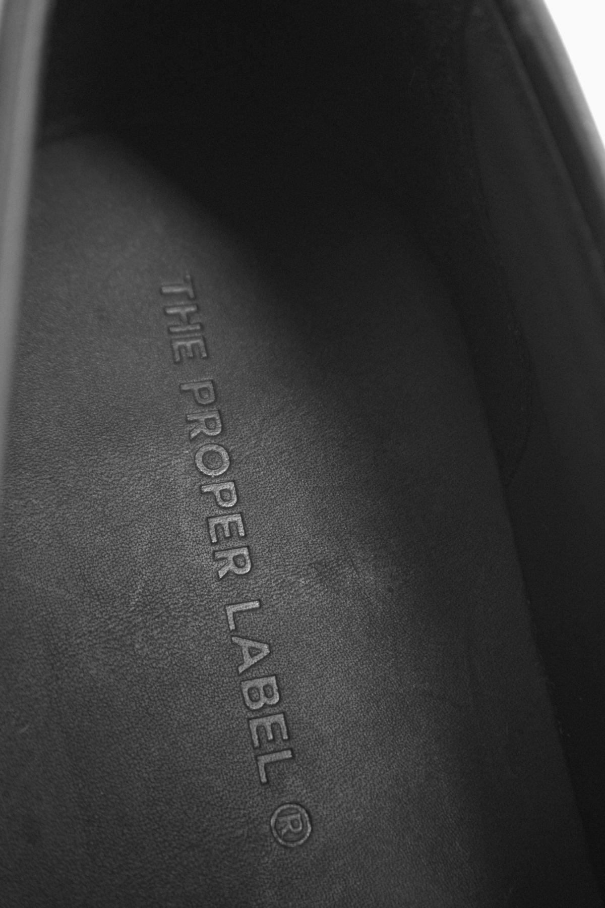 Close-up of the black leather interior of The Proper Moccasin, with The Proper Label® embossed on the insole.