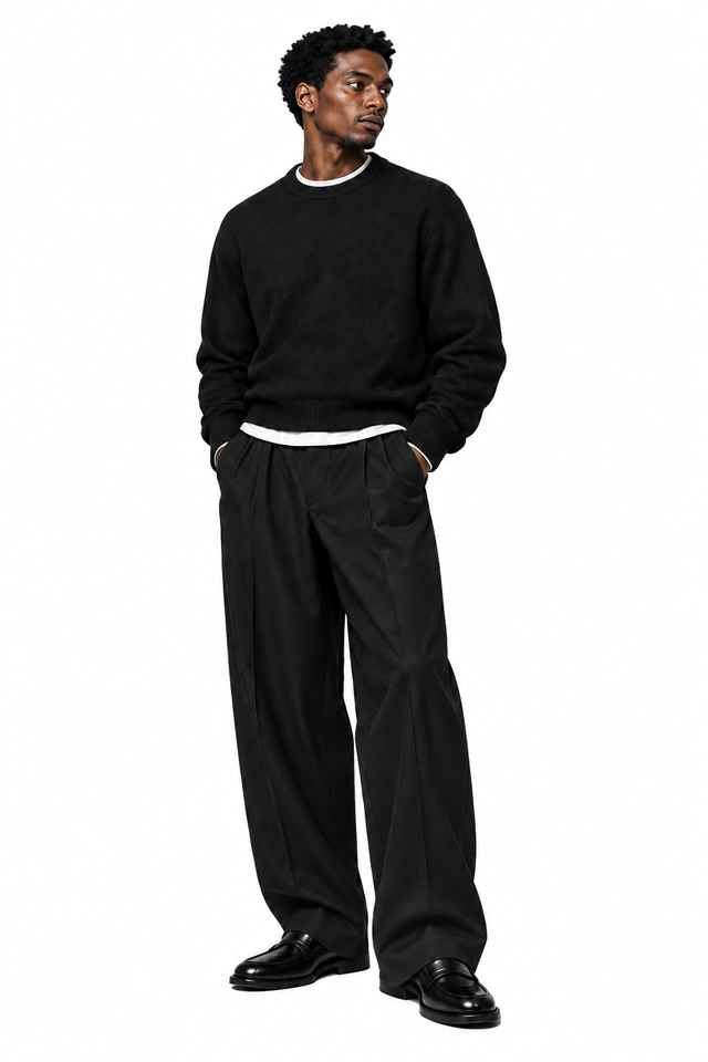 Silhouette décontractée en maille noire, pantalon noir ample et mocassins.