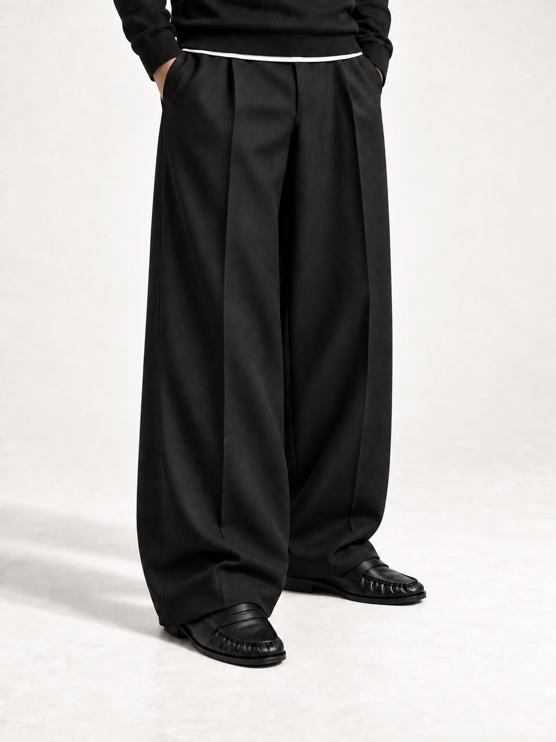 The Proper Moccasin® porté avec un pantalon noir ample et un pull noir.