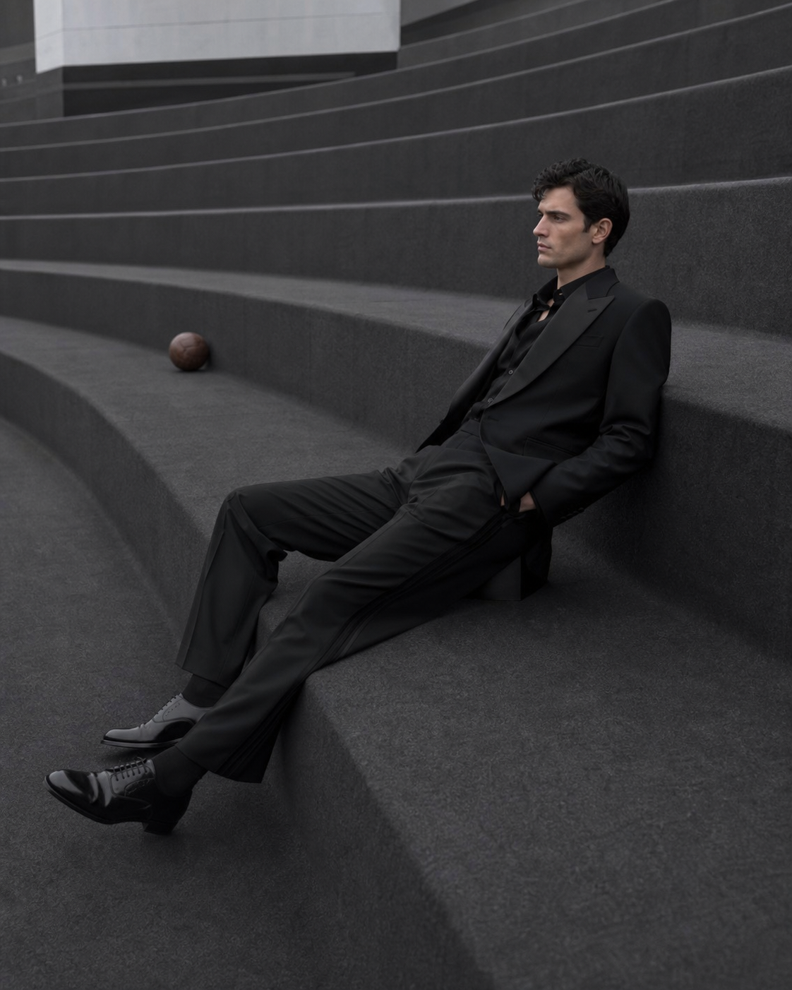 Campagne Maison de Sport : silhouette en tailoring noir sur les gradins de béton d’un stade.