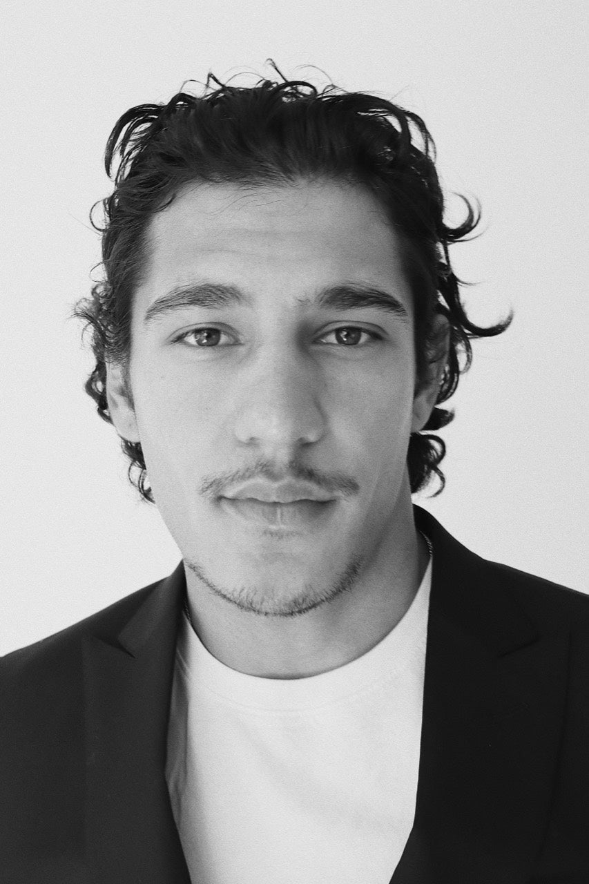 Front-facing portrait of Gabriel Robles wearing a black jacket and white T-shirt.
