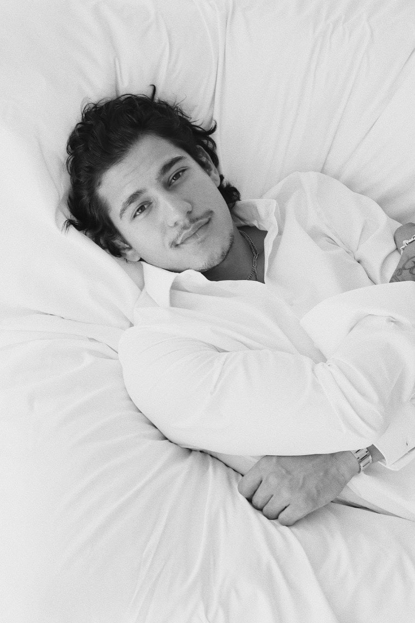 Close portrait of Gabriel Robles reclining against a white cushion.