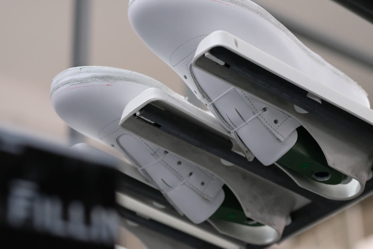 Two white sneaker uppers on lasts during construction.