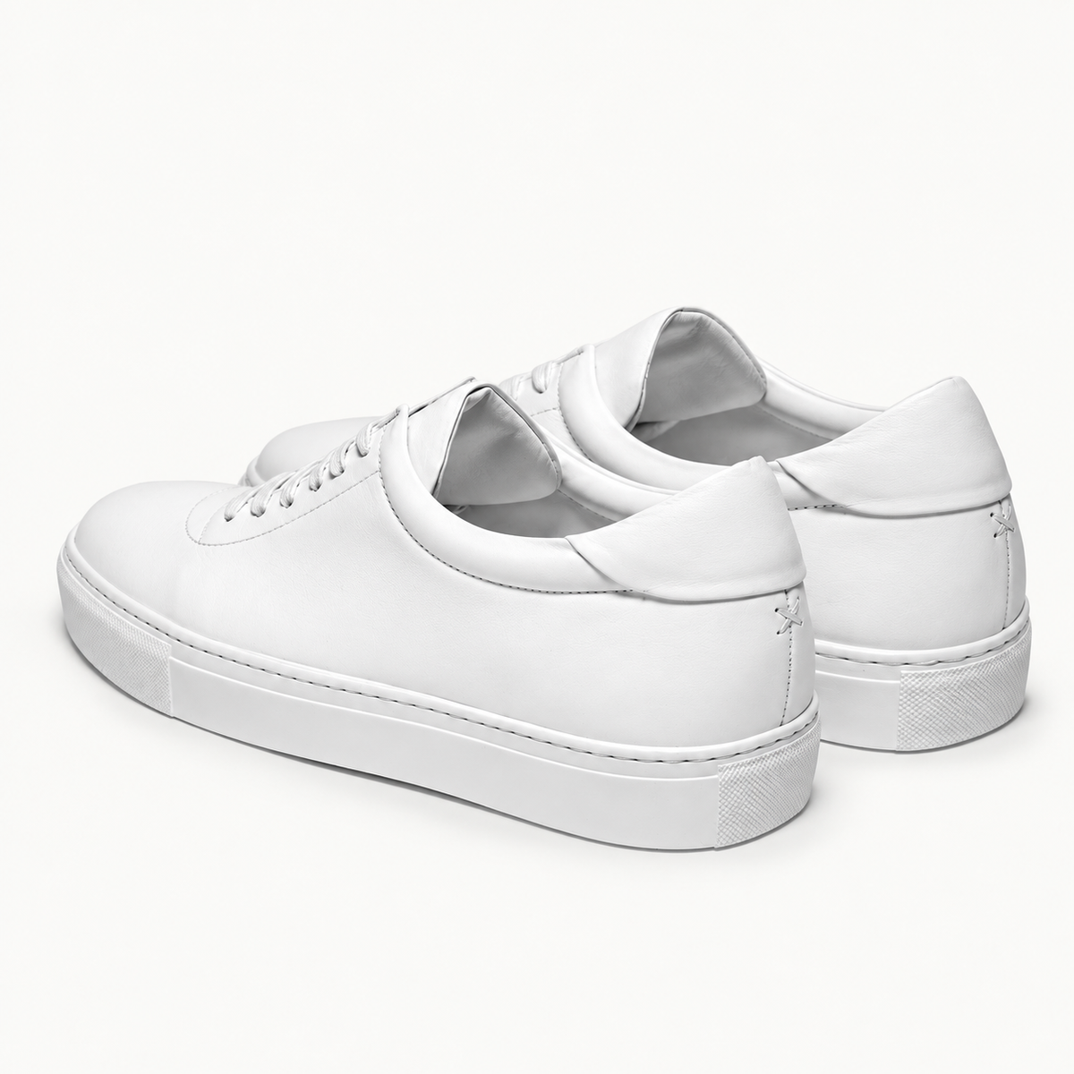 The Proper Sneaker® — white pair, heel panels and rear stitching.