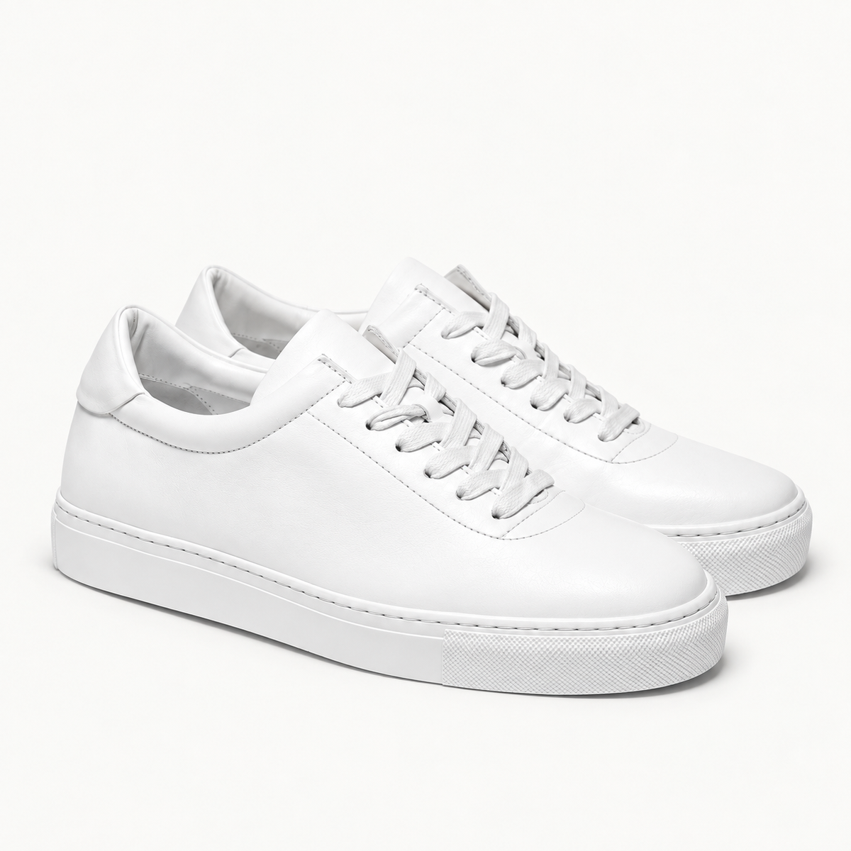 The Proper Sneaker® — white pair, front three-quarter view.
