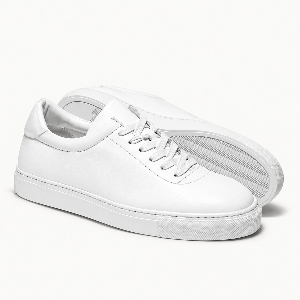 The Proper Sneaker® — white pair and wave-pattern rubber outsole.