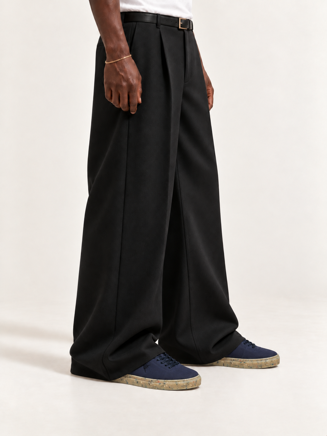 The Hampton Sneaker — Navy, worn with long black trousers, a tucked white T-shirt, a slim belt and discreet gold-tone accessories.