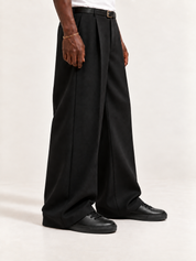The Proper High-Top Sneaker — Black, worn with long black trousers, a tucked white T-shirt, a slim belt and discreet gold-tone accessories.