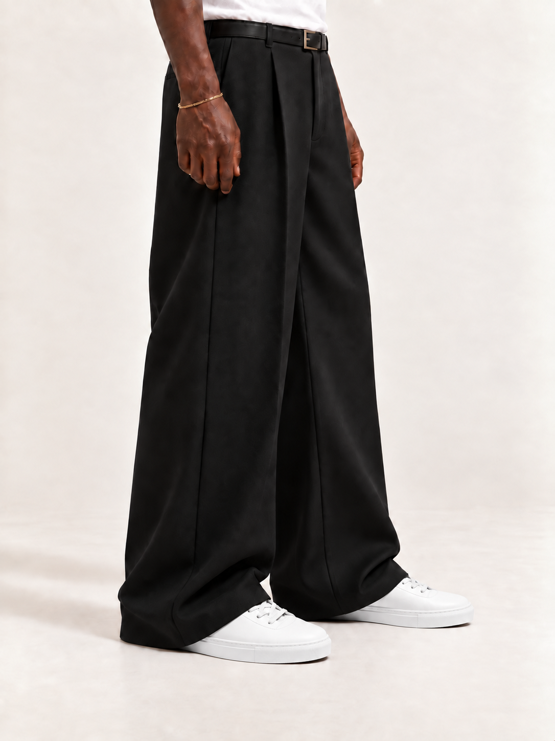 The Proper High-Top Sneaker — White, worn with long black trousers, a tucked white T-shirt, a slim belt and discreet gold-tone accessories.