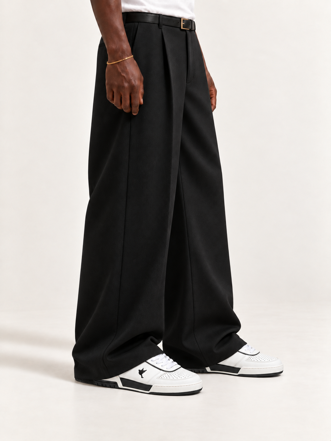 The PR003 — White / Black, worn with long black trousers, a tucked white T-shirt, a slim belt and discreet gold-tone accessories.
