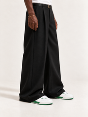 The PR003 — White / Green, worn with long black trousers, a tucked white T-shirt, a slim belt and discreet gold-tone accessories.