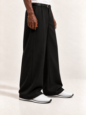 The Proper Runner — White, worn with long black trousers, a tucked white T-shirt, a slim belt and discreet gold-tone accessories.