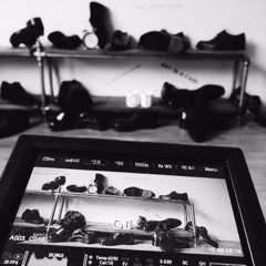 Un moniteur de tournage montre des étagères de chaussures, également visibles derrière l’écran.