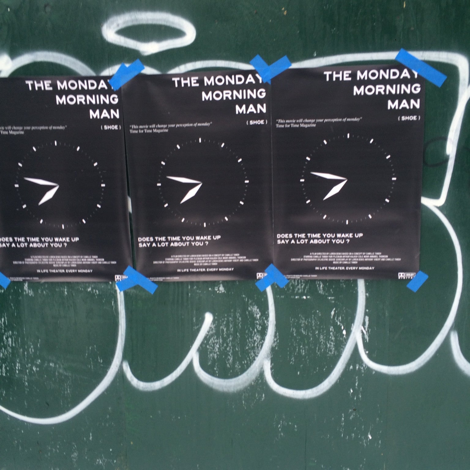 Trois affiches originales du film The Monday Morning Man fixées sur un mur peint avec du ruban bleu.