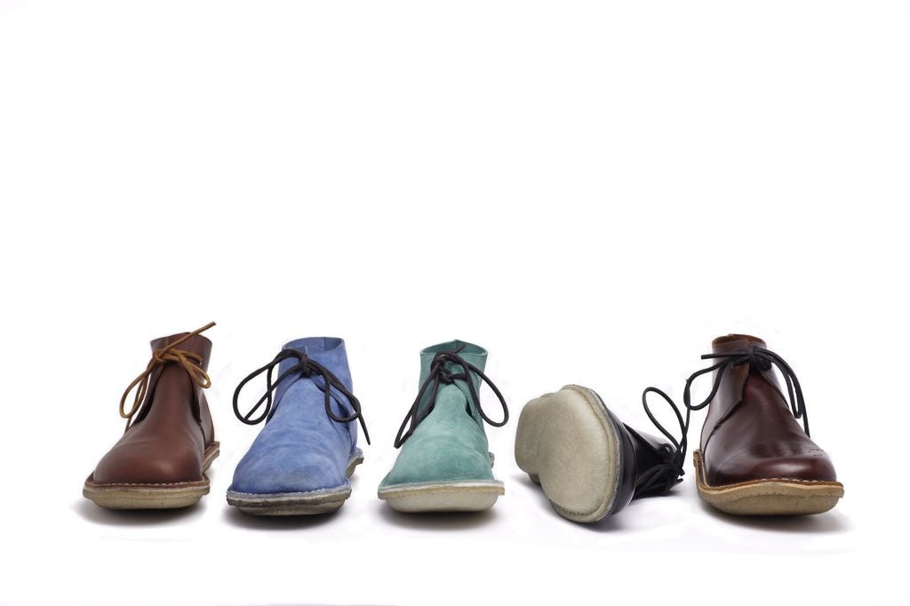 Cinq bottines THE SAMS sur fond blanc, dont une montre sa semelle