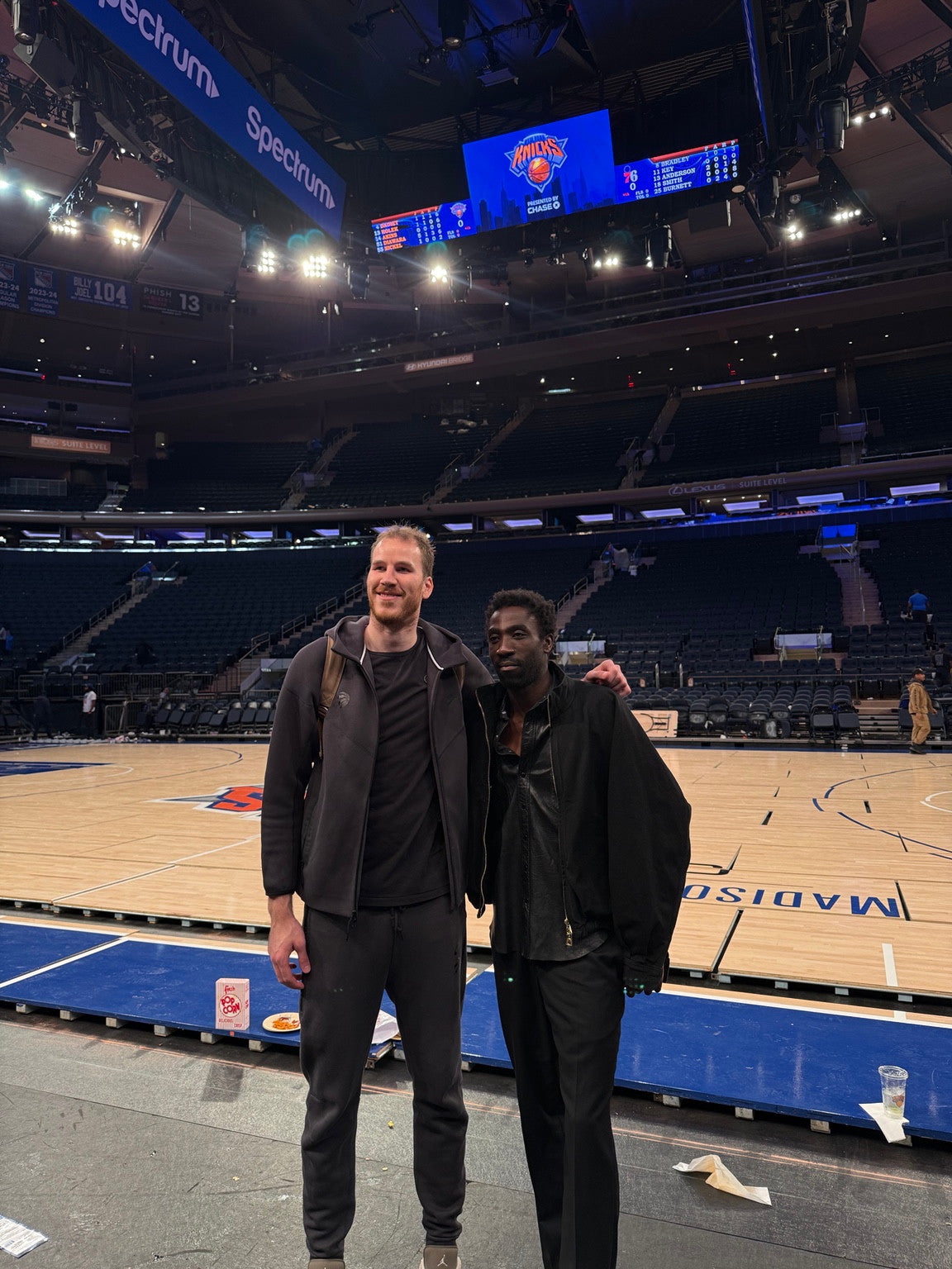 Two people posing courtside at Madison Square Garden.